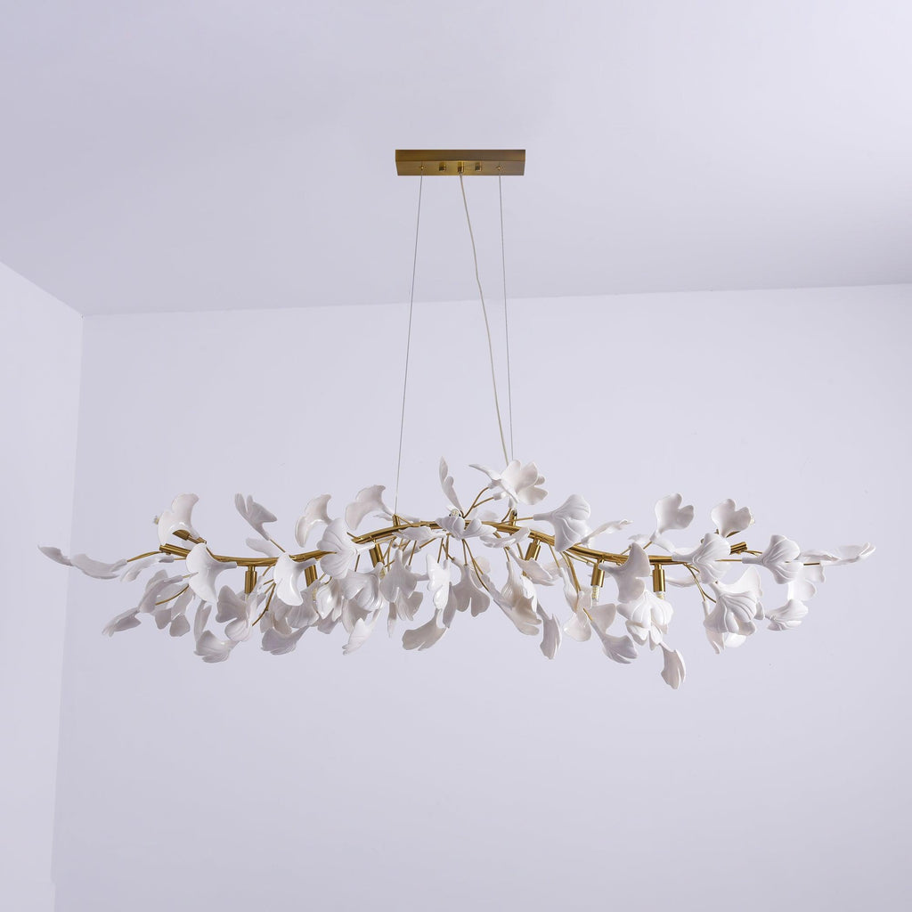 Clérachic leaf chandelier unlit against a pale lilac wall, with two suspension cables to a gold rectangular canopy.