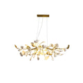 Clérachic chandelier with lit white leaves and gold curved ends, shown whole beneath a gold canopy on a white backdrop.