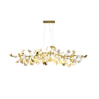 Clérachic chandelier with gold branch tips and gold-edged leaves among white ones, lit, on a plain white backdrop.