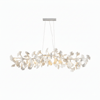 Full-width Clérachic chandelier of white ginkgo leaves, lit and hung from a nickel canopy on a plain white backdrop.