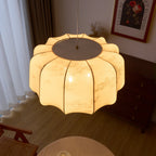 Clérachic scalloped fabric pendant light photographed from above, showing the charcoal-grey top cap and the panels overlapping as they radiate out over the floor below.