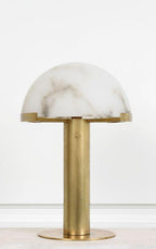 Front view of a gold Clérachic table lamp on a plain white ground, the cloud-veined alabaster dome resting on a brass collar.