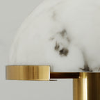 Close view of the grey-veined alabaster dome and brushed brass rim of this Clérachic table lamp.
