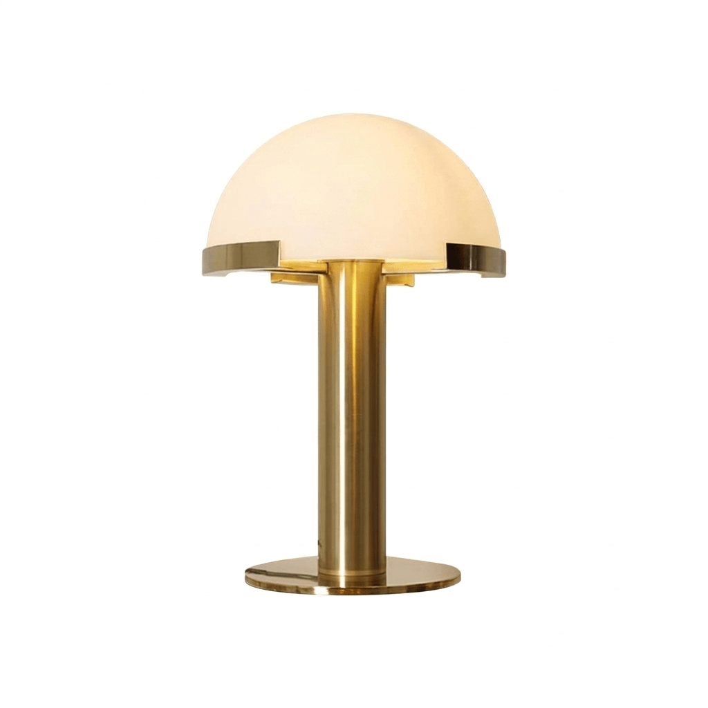 Gold Clérachic table lamp lit from within, with a brass stem and round base on a plain white background.