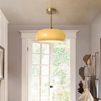 Clérachic Puffed Oval Glass Ceiling Light in orange glass, drop-rod mounted in an entry above a garden door and coat rail.