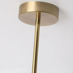 Close-up of the brushed brass canopy disc and slim drop rod on the Clérachic Puffed Oval Glass Ceiling Light.