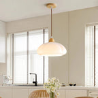Clérachic pendant light lit, the glow through the shade in a quiet room.