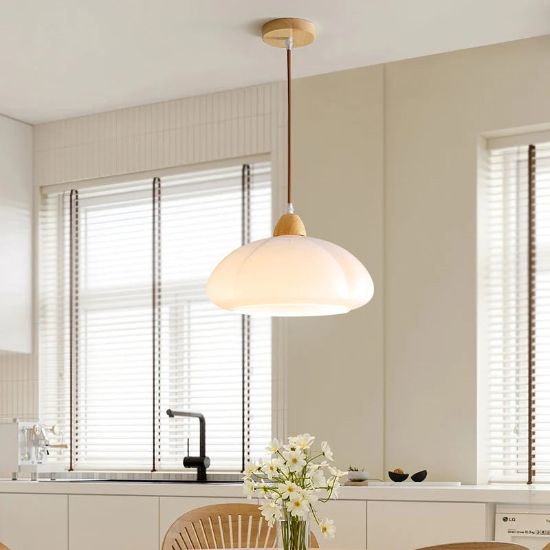 Clérachic pendant light lit, the glow through the shade in a quiet room.