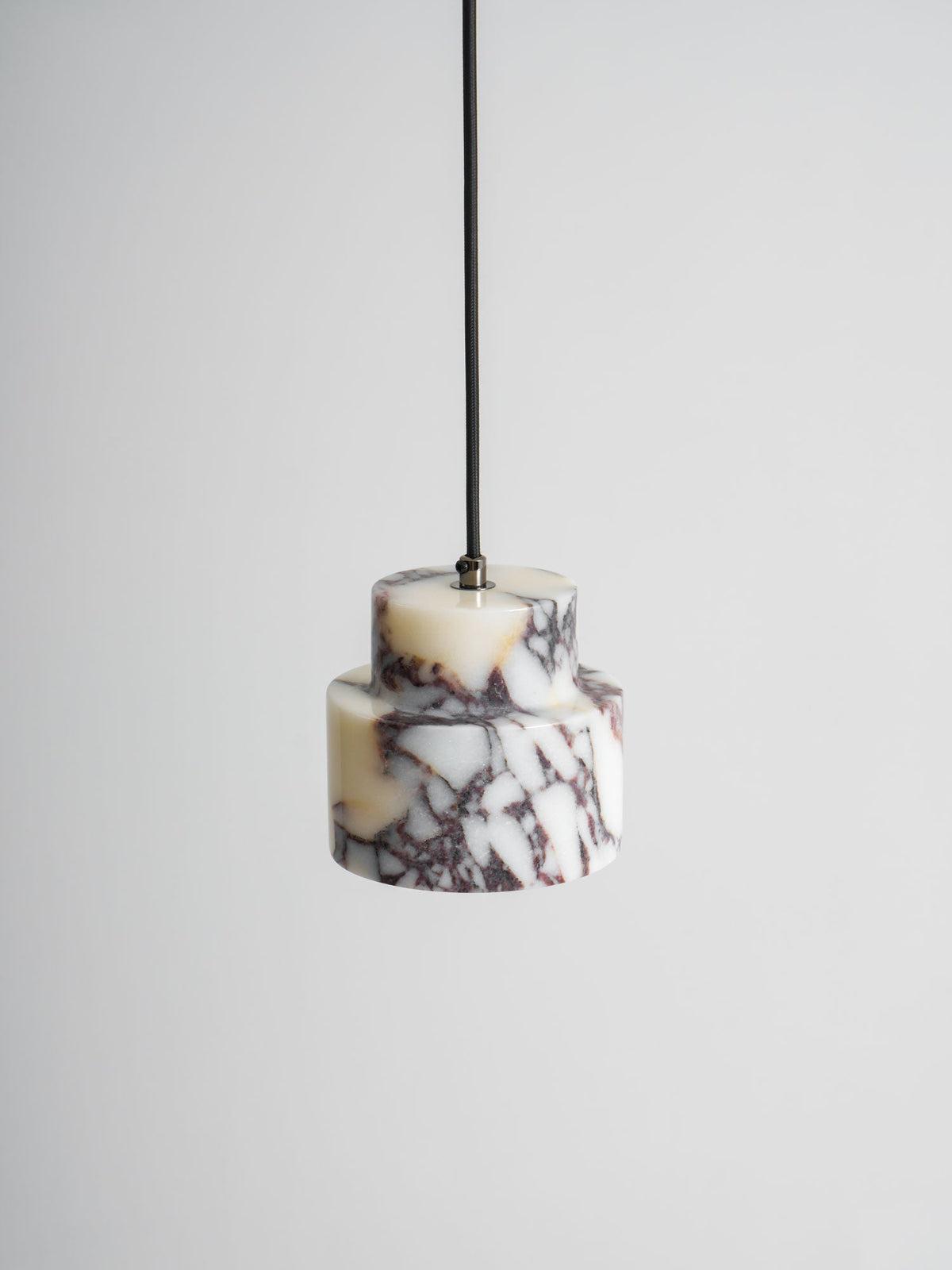 Close view of the white marble tiers of this Clérachic pendant, with plum-coloured veins and a dark cord above.