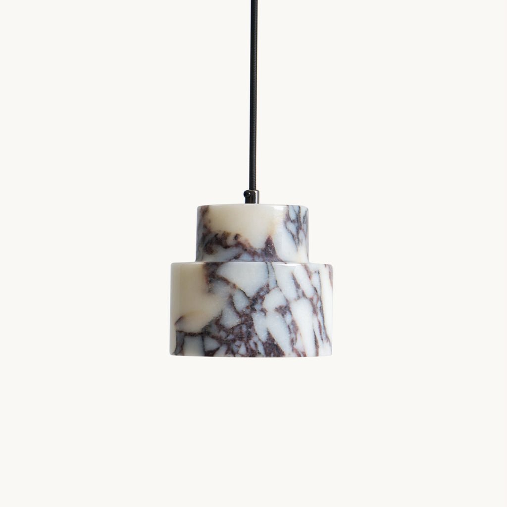 Close view of the unlit two-tier marble on this Clérachic pendant, with white, plum and grey veining on a cream backdrop.