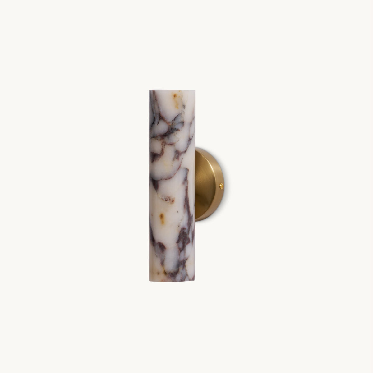 Slim cylindrical marble shade with purple veining on a round brass wall plate, this Clérachic wall light on a plain white backdrop.
