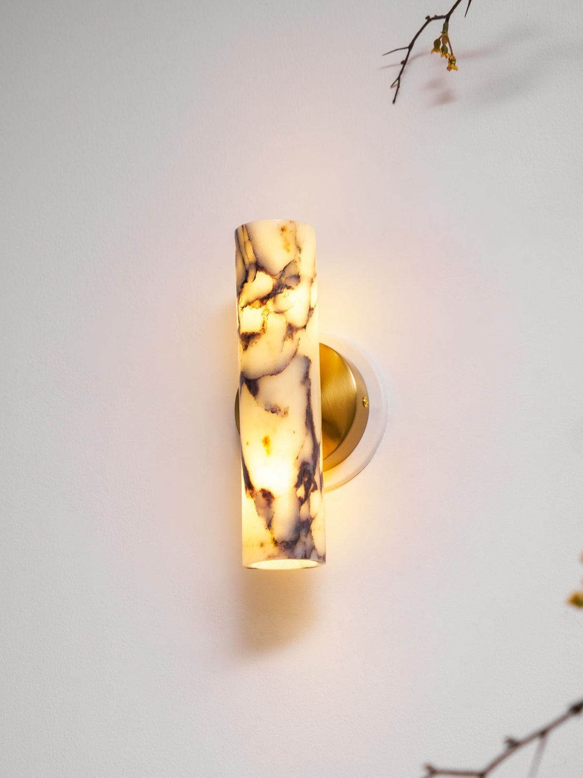 Lit Clérachic wall light seen close, with the shade's purple veining glowing and its lower opening showing warm light.