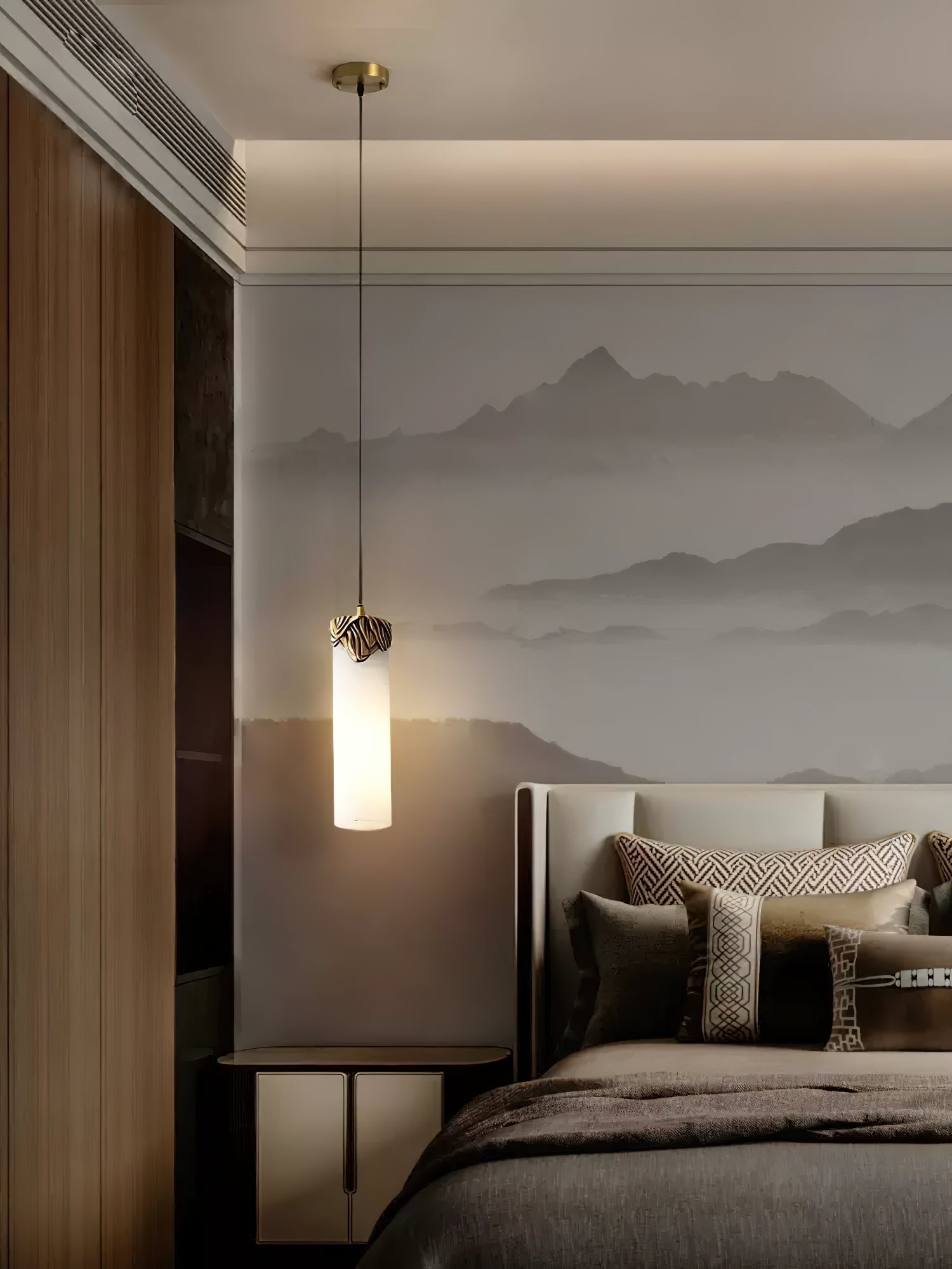 A Clérachic Quiver Pendant Light lit at the bedside against a misty mountain mural, hanging just above a low nightstand.