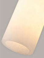 Macro of the lit Clérachic Quiver Pendant Light column, where the warm glow lifts the faint veining running through the alabaster.