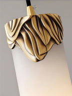 Detail of the sculpted brass cap on the Clérachic Quiver Pendant Light, its draped folds closing the top where the cord enters.