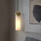 Clérachic Quiver Pendant Light lit in a bedroom corner beside a textured abstract canvas, hung low next to an upholstered headboard.
