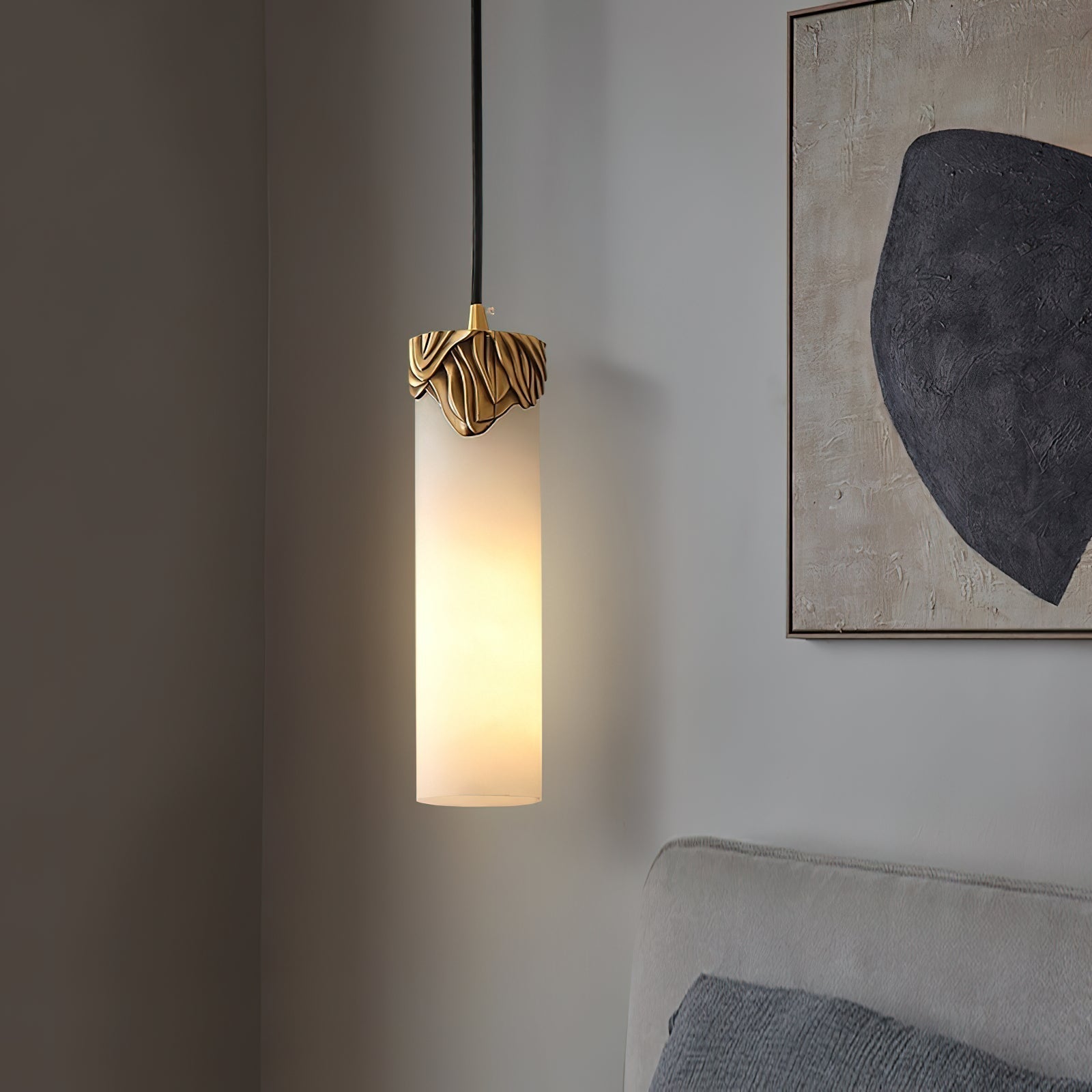 Clérachic Quiver Pendant Light lit in a bedroom corner beside a textured abstract canvas, hung low next to an upholstered headboard.