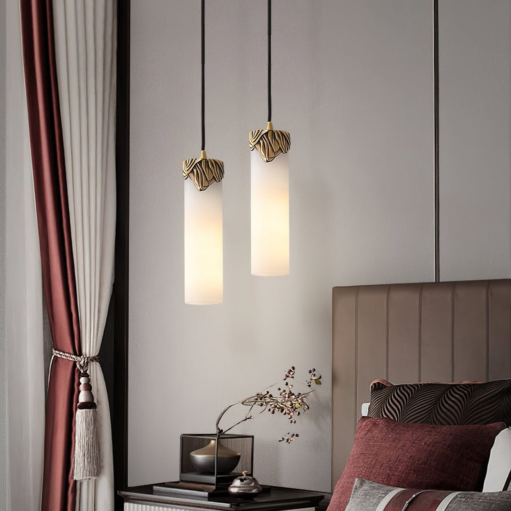 Two Clérachic Quiver Pendant Lights lit at staggered heights over a bedside table, freeing the surface beside a curtained window.