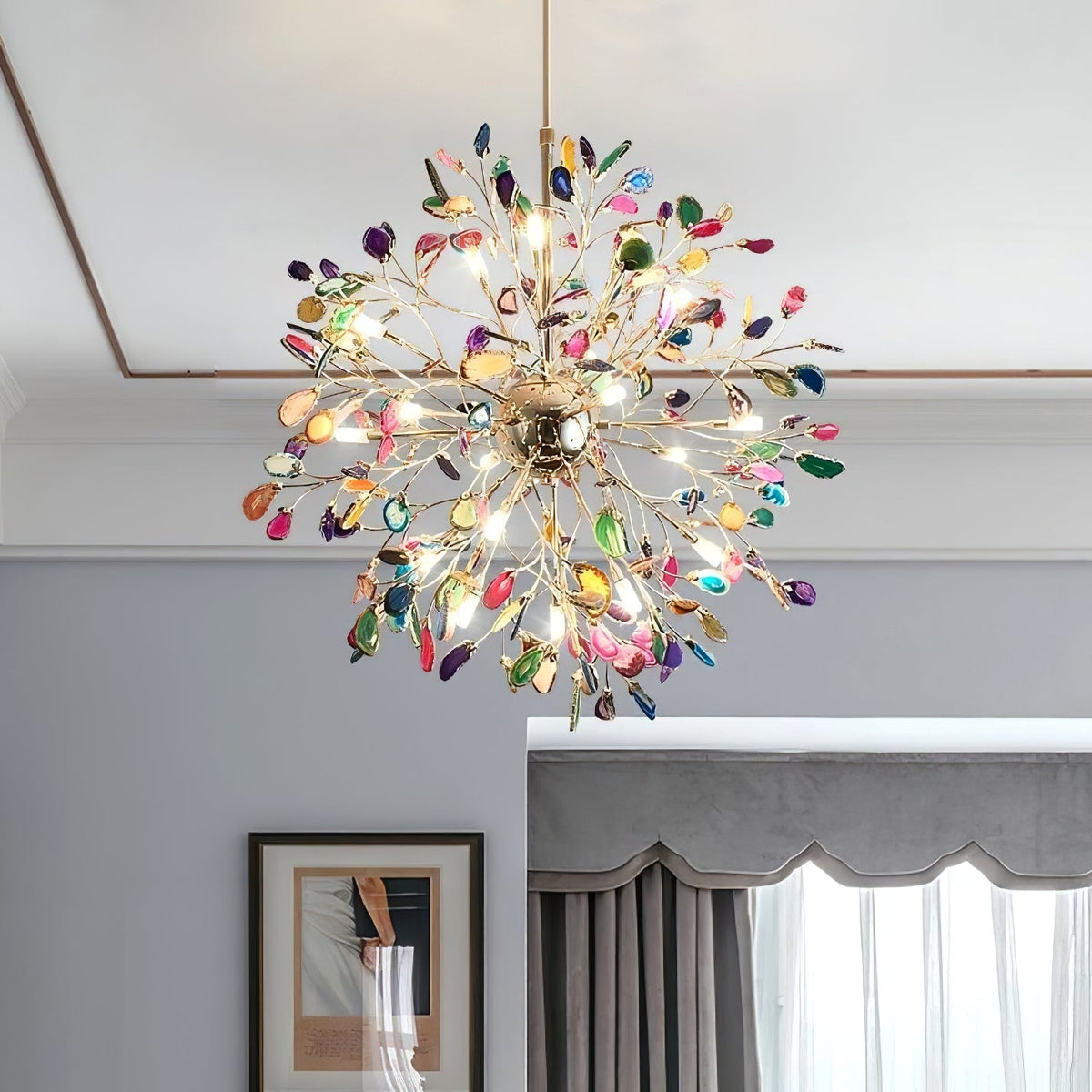 Clérachic multicolour agate chandelier seen from below, lit, in a room with a grey wall, a framed print and heavy curtains.