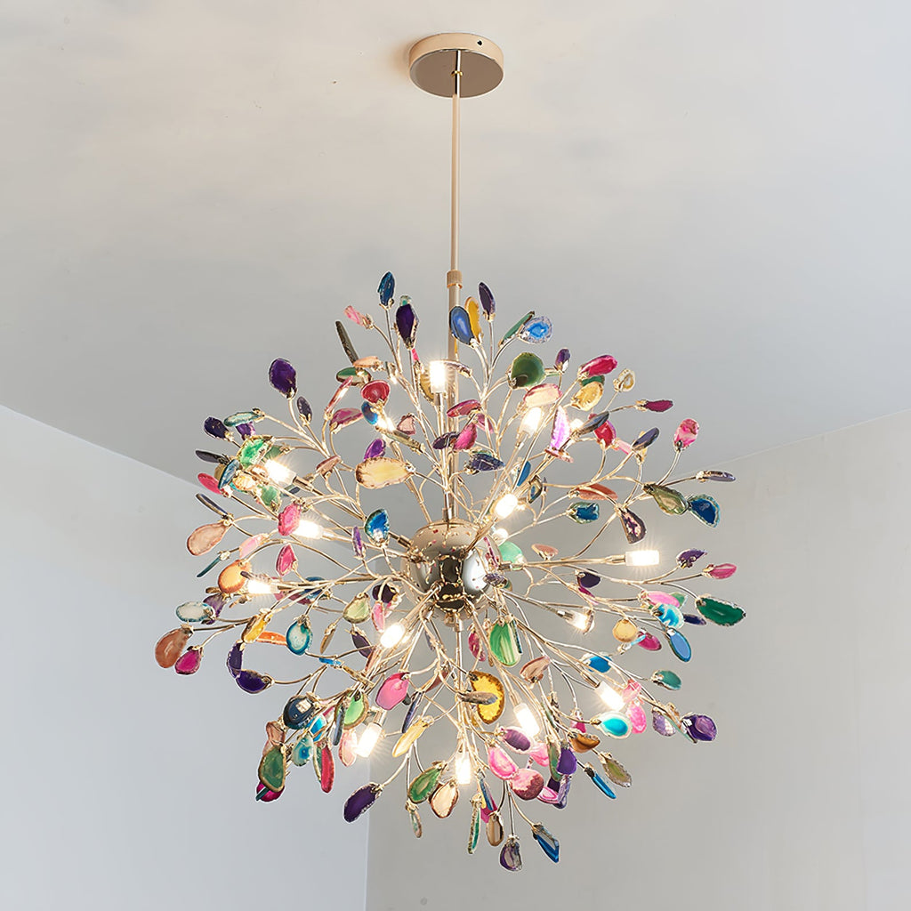 Close view from below of a lit Clérachic agate chandelier, its bulbs shining through slices in pink, green, blue and amber.