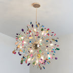 Close view from below of a lit Clérachic agate chandelier, its bulbs shining through slices in pink, green, blue and amber.