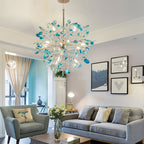 Blue-green agate Clérachic chandelier above a living room with a grey sofa, a blue armchair and framed prints on the wall.