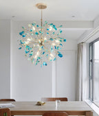 Blue-green agate Clérachic chandelier above a wooden dining table by a window with a sheer curtain.