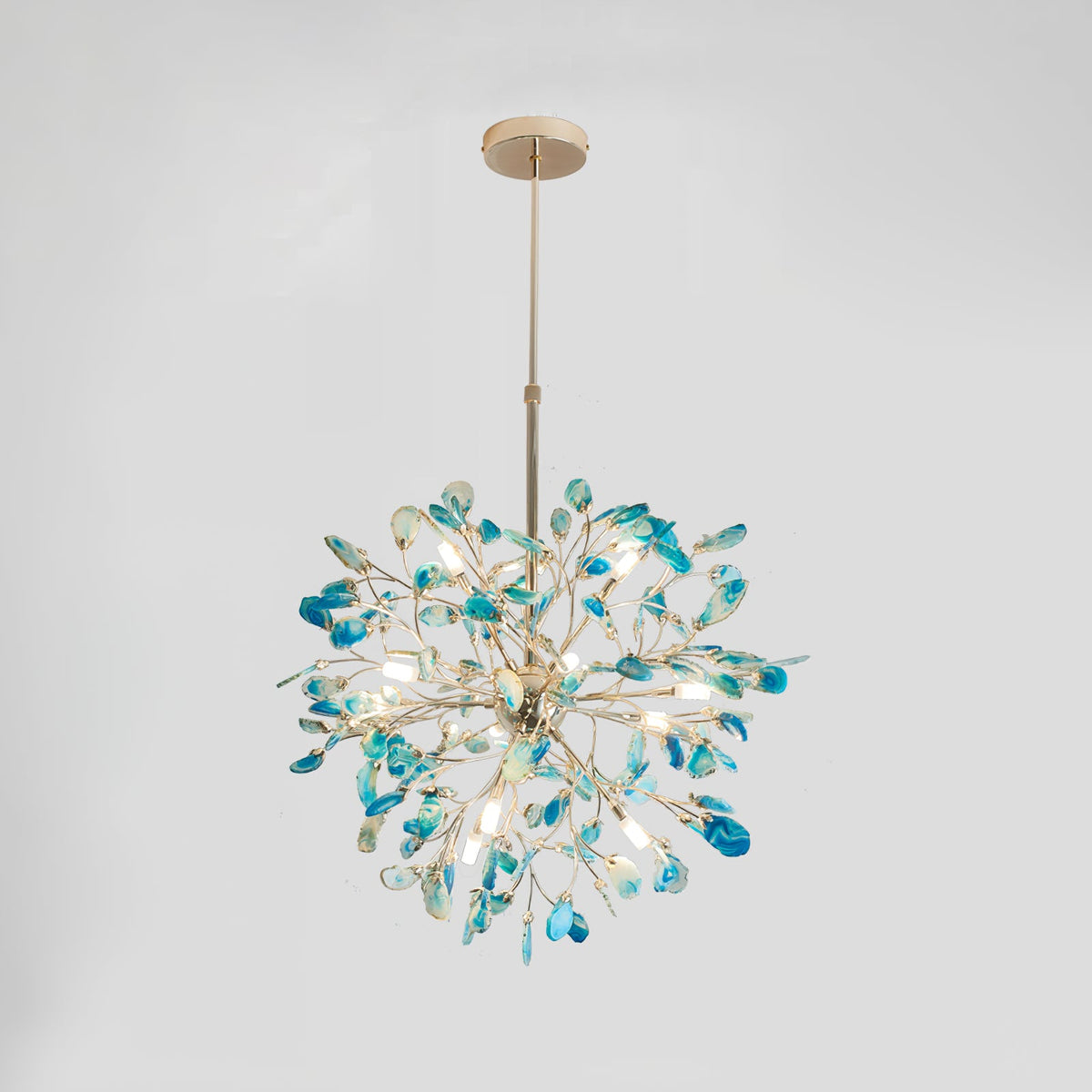 Clérachic agate chandelier with blue and teal slices on a pale grey backdrop, its gold branches spreading from a central sphere.