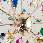 Close view of the gold sphere and branch tips of this Clérachic chandelier, with agate slices and small bulbs between the stems.