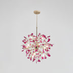Pink and magenta agate Clérachic chandelier on a pale grey backdrop, lit, hanging from a gold rod and round canopy.