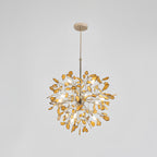 Amber agate Clérachic chandelier on a pale grey backdrop, lit, hanging from a gold rod and round canopy.