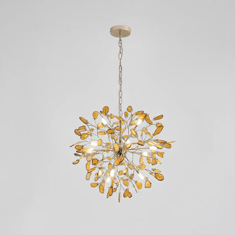 Amber agate Clérachic chandelier hanging from a fine gold chain, on a pale grey backdrop.