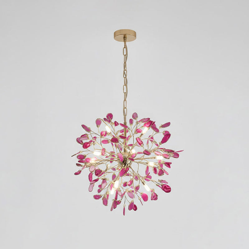 Pink agate Clérachic chandelier hanging from a gold chain on a pale grey backdrop, with rose slices around a central hub.