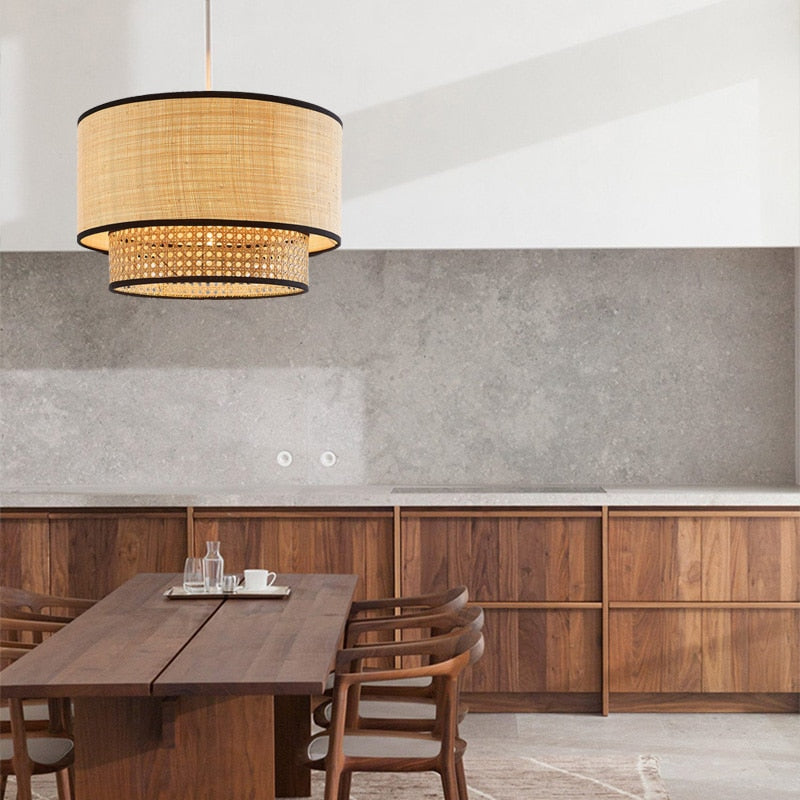 Clérachic raffia pendant lamp lit above a dark walnut dining table, against a continuous grey stone splashback above walnut cabinetry.