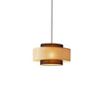 This Clérachic pendant on a white backdrop shows a wide rattan drum between two narrower brown fabric tiers.