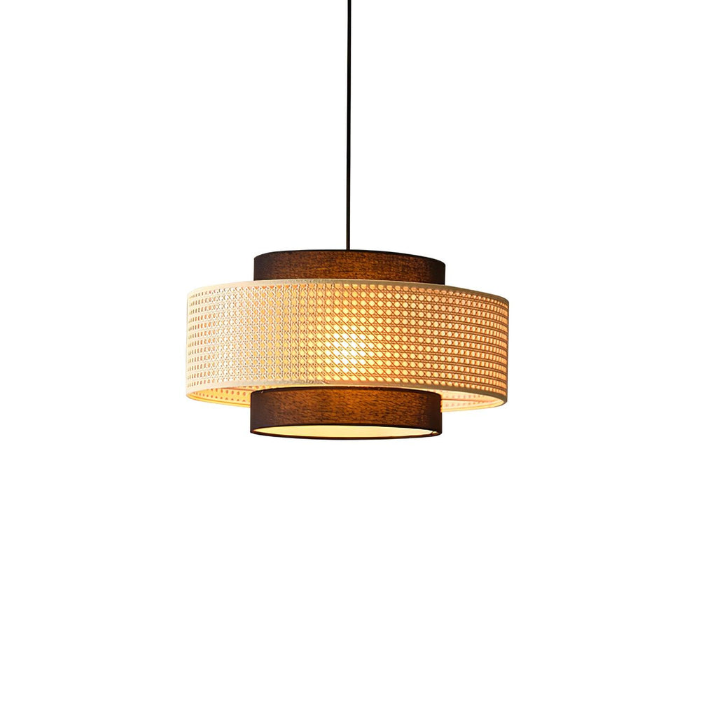 A Clérachic pendant with a perforated rattan drum and brown fabric tiers, seen at a slight angle on white.
