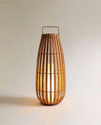 Clérachic tall slatted natural-fibre floor lantern with a slim handle and a glowing inner pillar light, large size.