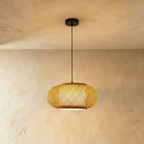 Clérachic woven pendant light in a flattened lantern shape with a crosshatch weave, lit warm on a black cord.