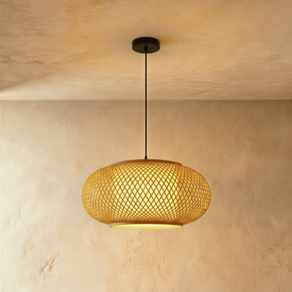 Clérachic large flattened woven pendant light, crosshatch weave glowing amber, hung from a black canopy and cord.
