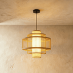 Clérachic tiered slatted drum pendant light with stacked rings around a glowing inner shade, in a smaller size.