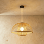 Clérachic large slatted dome pendant light with a broad rim ring and lower cage, bulb glowing, on a black cord.
