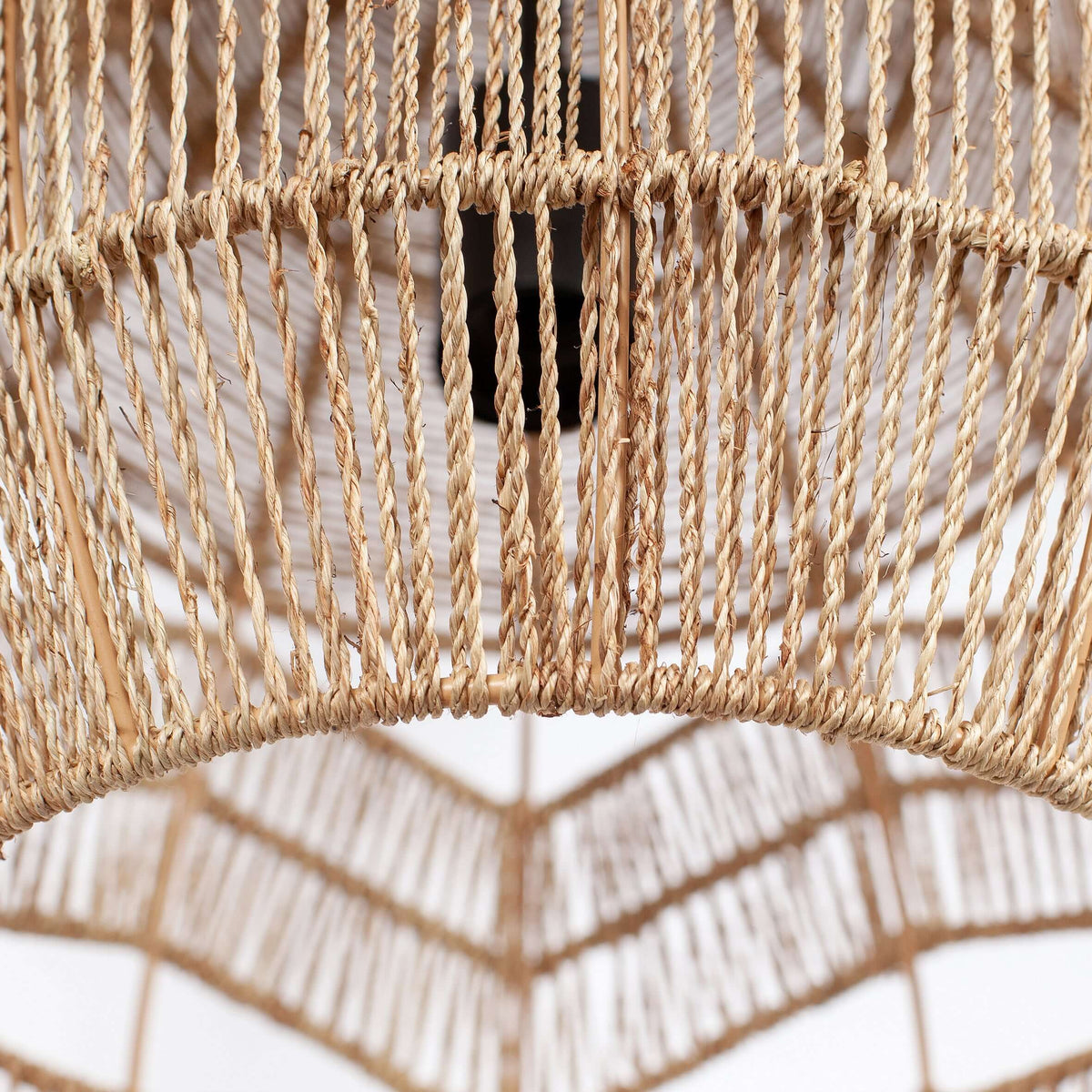 Close view of the natural rattan rope and the zigzag cut-outs inside the shade of this Clérachic pendant.