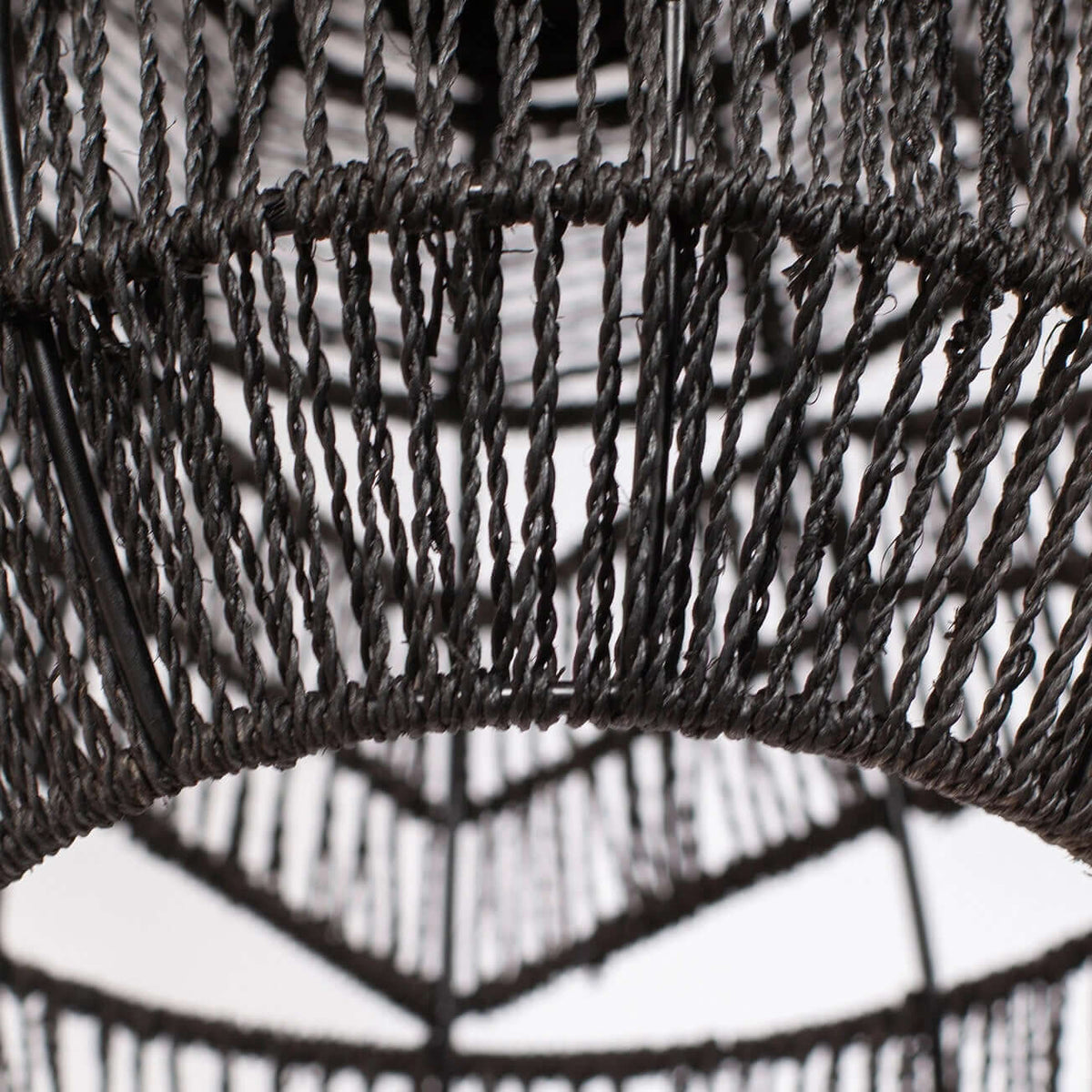 Close view of the twisted black rope weave and the lower rim of this Clérachic pendant.