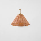A full underside view of the woven rattan cone shade on this Clérachic wall light, with the gold arm folded above it.