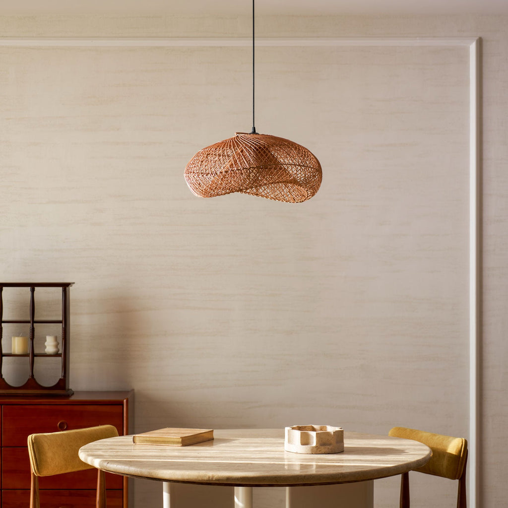 Warm-toned Clérachic open-weave pendant hung above a round table with mustard chairs, against a softly panelled cream wall.