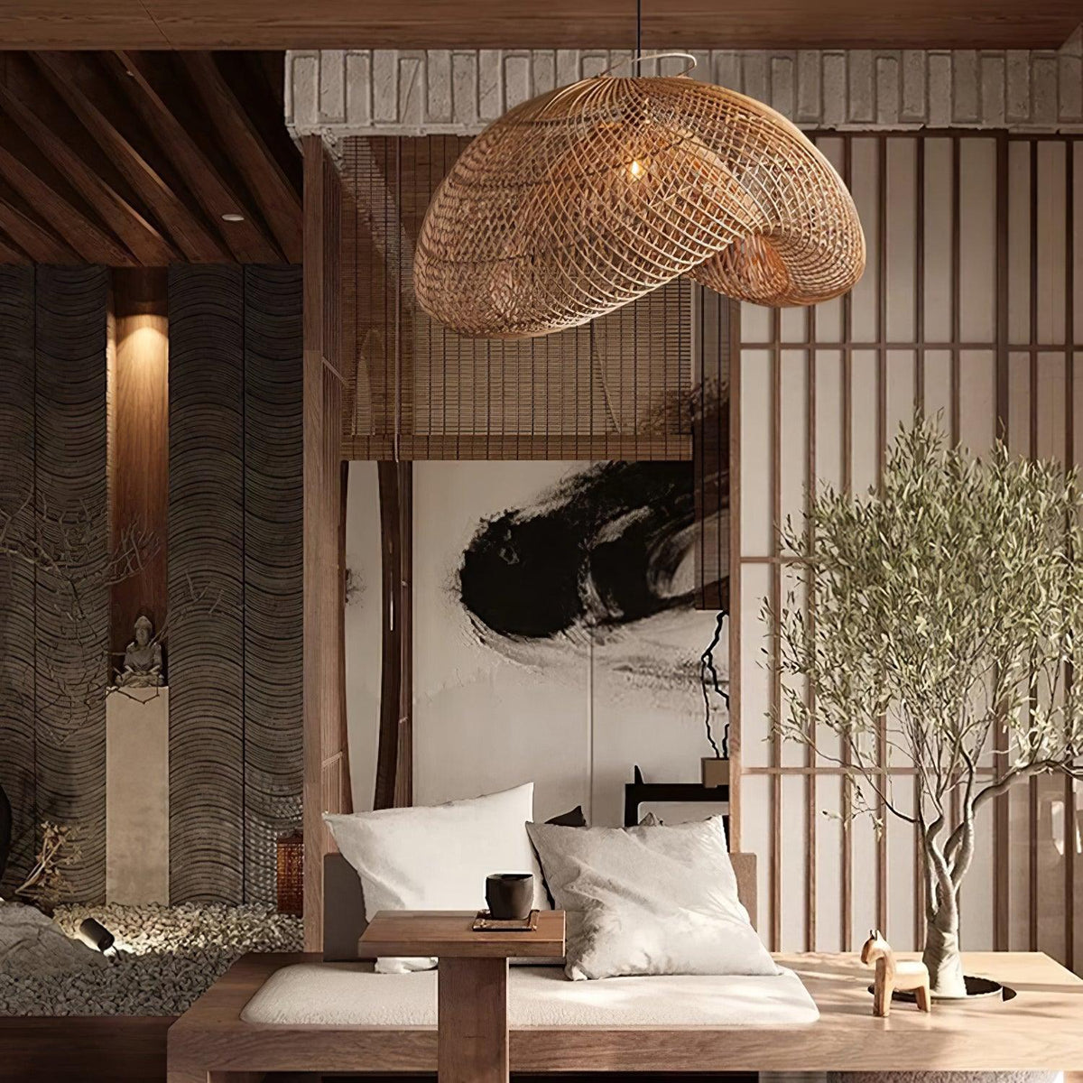 This Clérachic rattan pendant over a daybed in a timber-ceilinged room with slatted screens, an olive tree and a brush-ink painting.