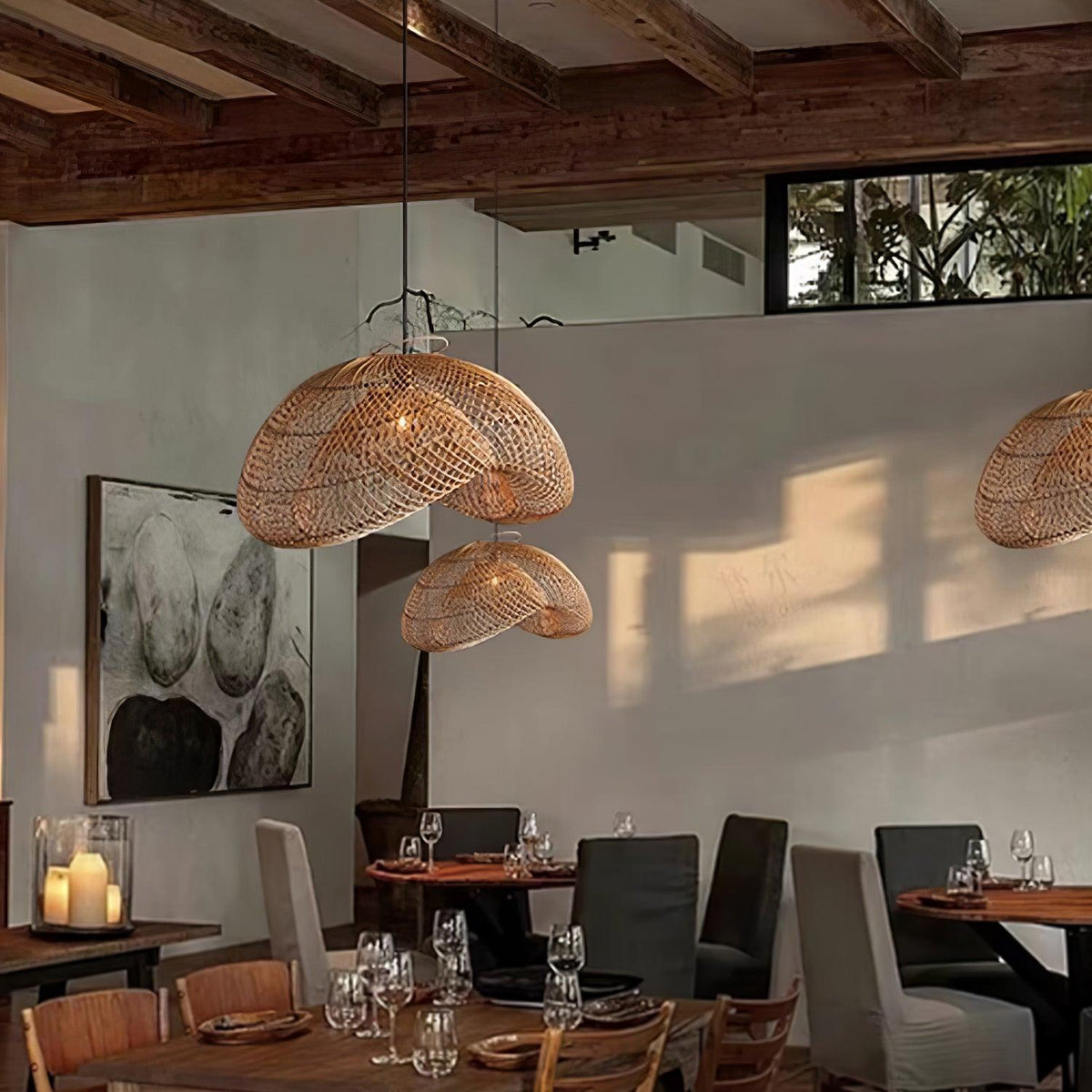 Clérachic rattan pendants hanging in a restaurant with exposed beams, a window high on the wall and set tables below.