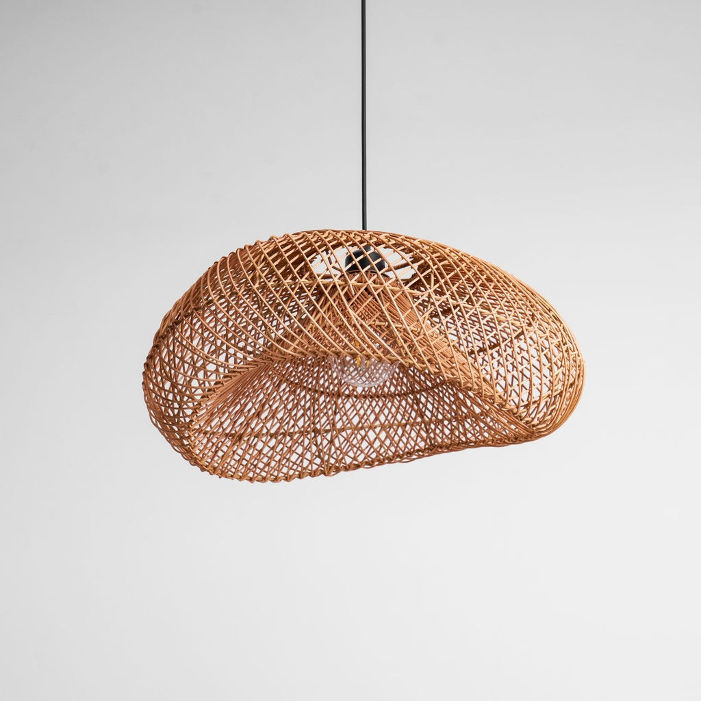 Underside of this Clérachic rattan wave pendant on grey, with the weave curling around the opening and the bulb inside.