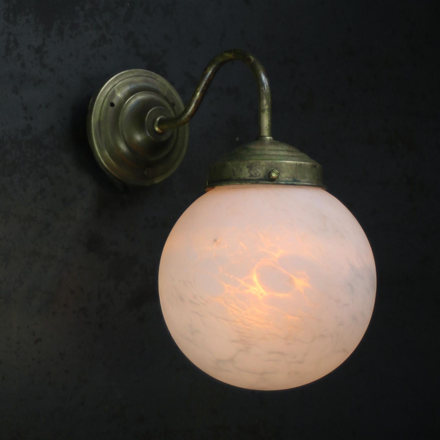 The Clérachic globe lit against dark metal, warm amber light glowing through the veined Spanish alabaster shade.