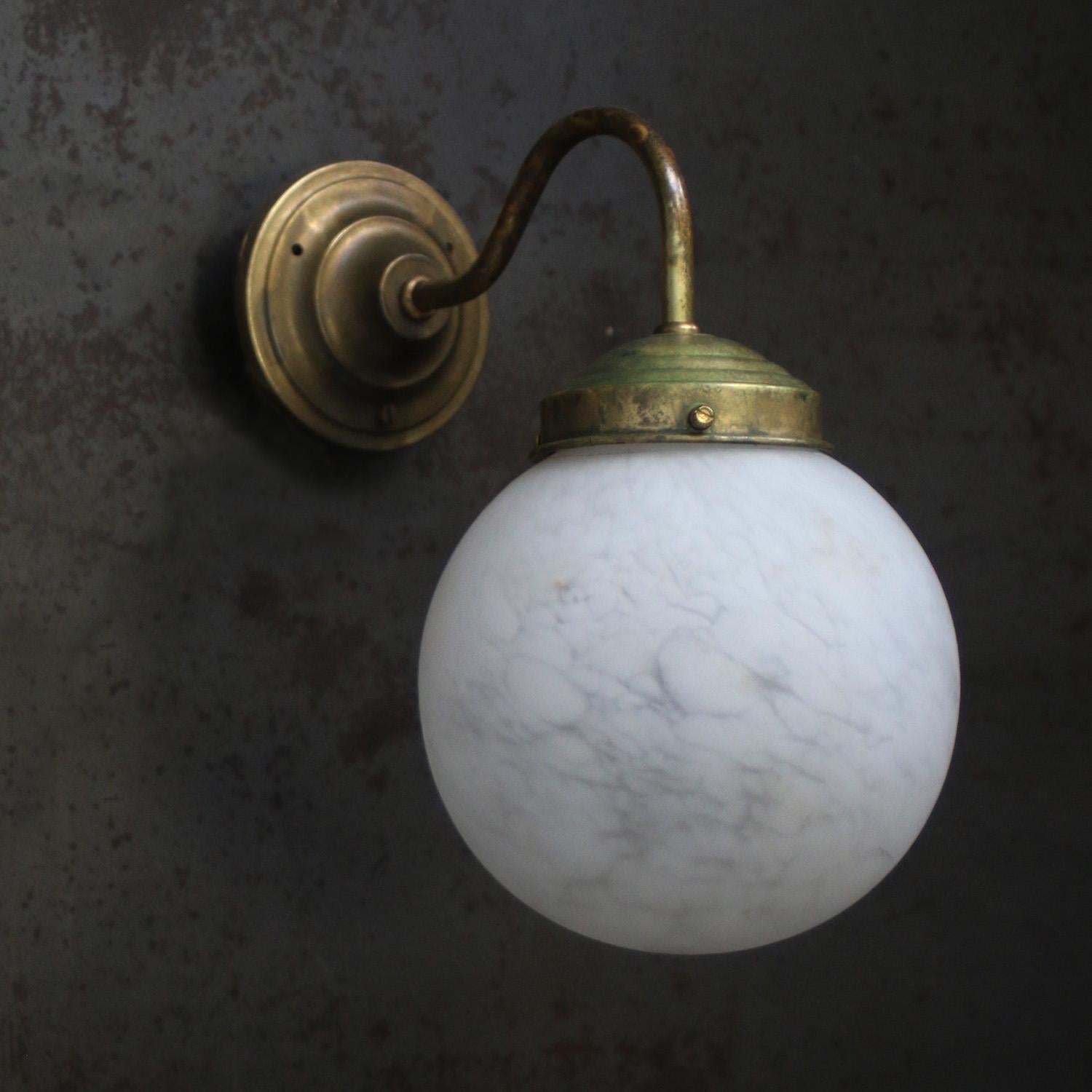 Clérachic wall light unlit on a dark steel wall, the cool grey veining of the alabaster sphere clearly visible.